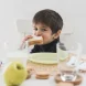 front-view-kid-eating-sandwich-table